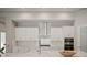 Modern kitchen with white cabinets, quartz countertops, and stainless steel appliances at 14292 Swiss Bridge Dr, Riverview, FL 33579