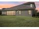 Home's back exterior showcasing a screened patio and lawn at 14292 Swiss Bridge Dr, Riverview, FL 33579