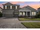 Two-story home with gray siding, a three-car garage, and a landscaped front yard at 14292 Swiss Bridge Dr, Riverview, FL 33579