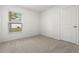 Well-lit bedroom featuring neutral carpeting and a window at 5093 Burnside St, North Port, FL 34291