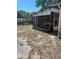 Backyard with screened enclosure and overgrown grass at 10007 N 26Th St, Tampa, FL 33612