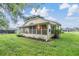 View of a house's screened porch surrounded by lush lawn at 6928 Stephens Path, Zephyrhills, FL 33542