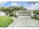 House exterior featuring a two-car garage and landscaped yard at 6928 Stephens Path, Zephyrhills, FL 33542