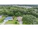 Aerial view of two houses in a tree-lined neighborhood at 6928 Stephens Path, Zephyrhills, FL 33542