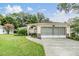 House exterior with a two-car garage and well-maintained lawn at 6928 Stephens Path, Zephyrhills, FL 33542