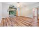 Bright living room with laminate floors and sliding glass doors leading to a screened porch at 6928 Stephens Path, Zephyrhills, FL 33542