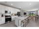 Modern, open-concept kitchen featuring stainless steel appliances, light quartz countertops, and a spacious island with seating at 4717 Blue Star Ct, North Port, FL 34289