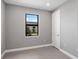 Well-lit bedroom with gray walls, wood-look floors, and a window at 4717 Blue Star Ct, North Port, FL 34289