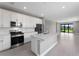 Modern kitchen with white cabinets, quartz countertops, and stainless steel appliances at 4717 Blue Star Ct, North Port, FL 34289