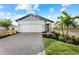 One-story home with gray siding, white garage door, and landscaped yard at 4717 Blue Star Ct, North Port, FL 34289