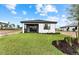 Rear view of a single-story home with a covered lanai and grassy yard at 4717 Blue Star Ct, North Port, FL 34289