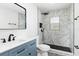 Modern bathroom with marble-tiled shower, black fixtures, and blue vanity at 801 Brodhag Dr, Punta Gorda, FL 33950