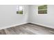 Clean bedroom with gray wood-look floors, two windows, and fresh white walls at 801 Brodhag Dr, Punta Gorda, FL 33950