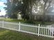 House exterior showcasing a white picket fence and lush green lawn at 10520 Henderson Rd, Tampa, FL 33625