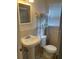 Clean bathroom with pedestal sink, toilet and shelving unit at 90 144Th Ave # 7, Madeira Beach, FL 33708