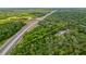 Aerial view showing a large lot next to a highway, surrounded by lush trees at 16637 Livingston Ave, Lutz, FL 33559