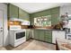 Galley style kitchen with green cabinets and tin backsplash at 16637 Livingston Ave, Lutz, FL 33559