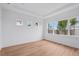 A spacious, light-filled bedroom with a large window, tray ceiling and beautiful light colored wood flooring at 8320 Golden Beach Ct, Parrish, FL 34219