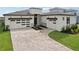 Paver driveway leading to a modern home with a well-manicured lawn and clean lines at 8320 Golden Beach Ct, Parrish, FL 34219