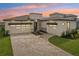 Modern two-story home featuring a three-car garage, and a brick driveway at 8320 Golden Beach Ct, Parrish, FL 34219
