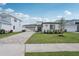 Contemporary one-story home with well-manicured landscaping, green lawn, and brick driveway at 8320 Golden Beach Ct, Parrish, FL 34219