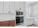 White kitchen cabinets with built-in microwave and oven appliances at 8320 Golden Beach Ct, Parrish, FL 34219