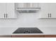 Close-up of the stovetop with a modern range hood and white backsplash at 8320 Golden Beach Ct, Parrish, FL 34219