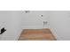Bright laundry room with wood grain flooring and white walls at 8320 Golden Beach Ct, Parrish, FL 34219