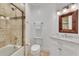 Bathroom featuring shower over tub with neutral tile, white vanity with marble countertop and wood framed mirror at 16300 Gulf Blvd # 300B, Redington Beach, FL 33708