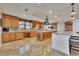 Large kitchen featuring custom cabinetry, marble countertops, a kitchen island, and barstool seating at 16300 Gulf Blvd # 300B, Redington Beach, FL 33708