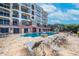 Inviting condo complex pool with elegant lounge chairs and lush landscaping for relaxation at 16300 Gulf Blvd # 300B, Redington Beach, FL 33708