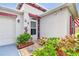 Inviting home exterior with landscaped walkway and red door at 2112 Purple Orchid Pl, Ruskin, FL 33570