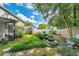 Lush backyard with a water feature, screened patio, and wooden fence at 9527 Pebble Glen Ave, Tampa, FL 33647