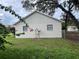 Rear view of house with satellite dish and landscaping at 39616 Meadowood Loop, Zephyrhills, FL 33542