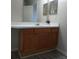 Bathroom vanity with white countertop and wood cabinets, with a decorative flower at 5125 Palm Springs Blvd # 1303, Tampa, FL 33647