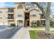 Exterior of a tan building with garages, balconies, and manicured landscaping at 5125 Palm Springs Blvd # 1303, Tampa, FL 33647