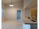 Bright kitchen featuring white tile floors, a long counter, and views of a laundry room at 5125 Palm Springs Blvd # 1303, Tampa, FL 33647