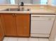 Kitchen sink and dishwasher beneath a countertop with wooden cabinetry at 5125 Palm Springs Blvd # 1303, Tampa, FL 33647