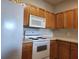 Kitchen featuring wooden cabinetry, white appliances, and a white countertop at 5125 Palm Springs Blvd # 1303, Tampa, FL 33647