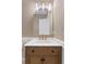 Elegant powder room with a marble countertop, arched mirror, and woven vanity at 2312 S Occident St, Tampa, FL 33629