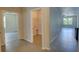 Hallway with tile flooring, laundry closet, and access to bedrooms at 9538 Highland Ridge Dr, Hudson, FL 34667