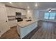 Kitchen boasts an island with sink, stainless appliances, granite countertops, and open access to living area at 3769 S Haberland Blvd, North Port, FL 34288