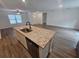 Kitchen island with sink, granite counters, stainless steel appliances, and open to living area at 3769 S Haberland Blvd, North Port, FL 34288