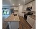Modern kitchen features an island with sink, granite countertops, and stainless steel appliances at 3769 S Haberland Blvd, North Port, FL 34288