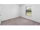 Simple bedroom with neutral carpeting and window with blinds at 3769 S Haberland Blvd, North Port, FL 34288