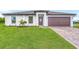 Modern house exterior with a paved driveway and landscaping at 5473 Colfax Ter, Port Charlotte, FL 33981