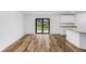 Living room with sliding glass doors and wood flooring, view of kitchen at 12564 Feldman Ave, Port Charlotte, FL 33981