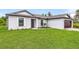 White single story house with dark brown garage door and green lawn at 12564 Feldman Ave, Port Charlotte, FL 33981