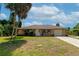 Single story home with attached garage and palm trees at 1402 Viscaya Dr, Port Charlotte, FL 33952