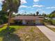 Aerial view of yellow house with driveway and palm trees at 1402 Viscaya Dr, Port Charlotte, FL 33952